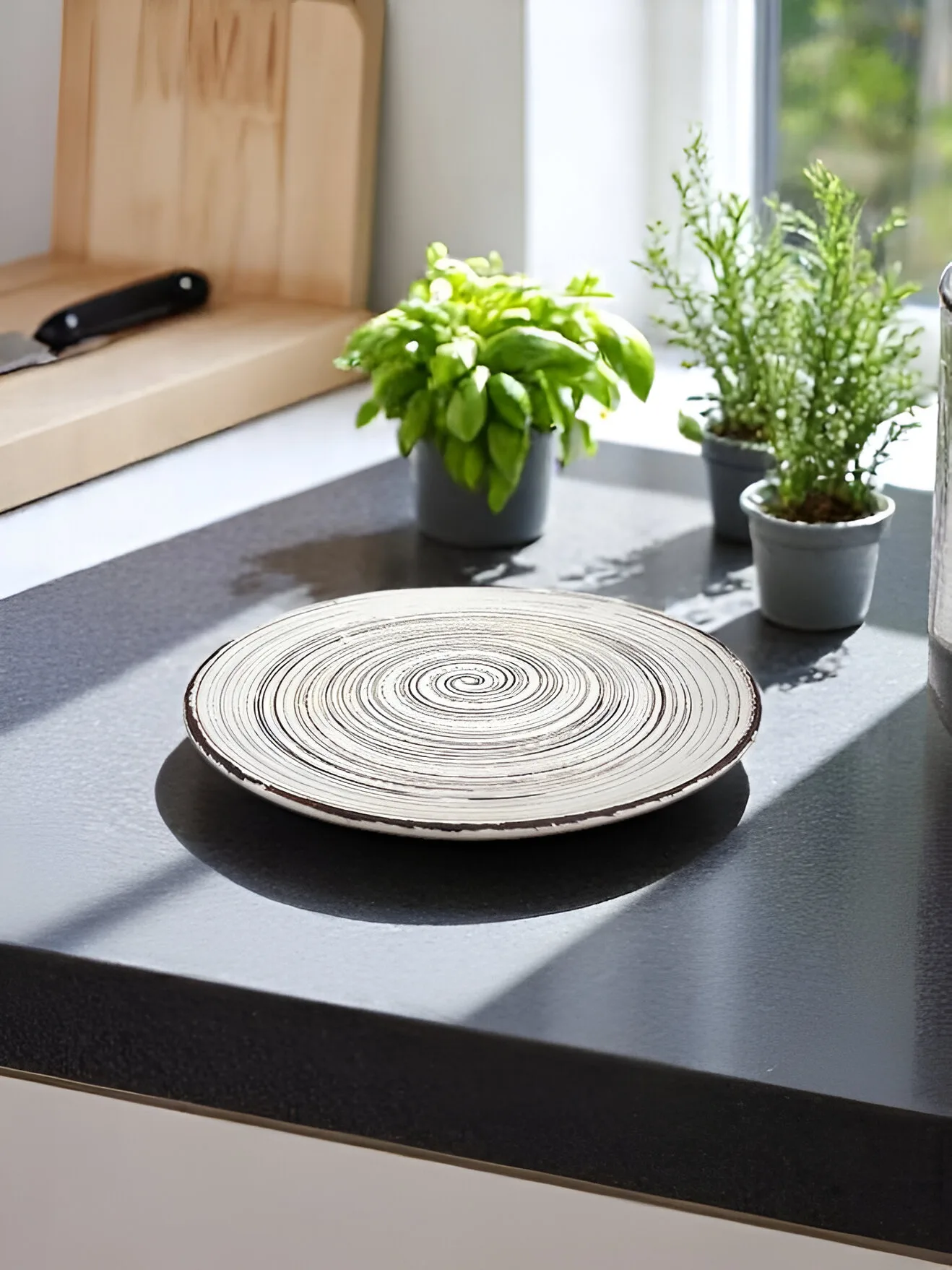 Handmade spiral ceramic plate with an artistic swirl design.